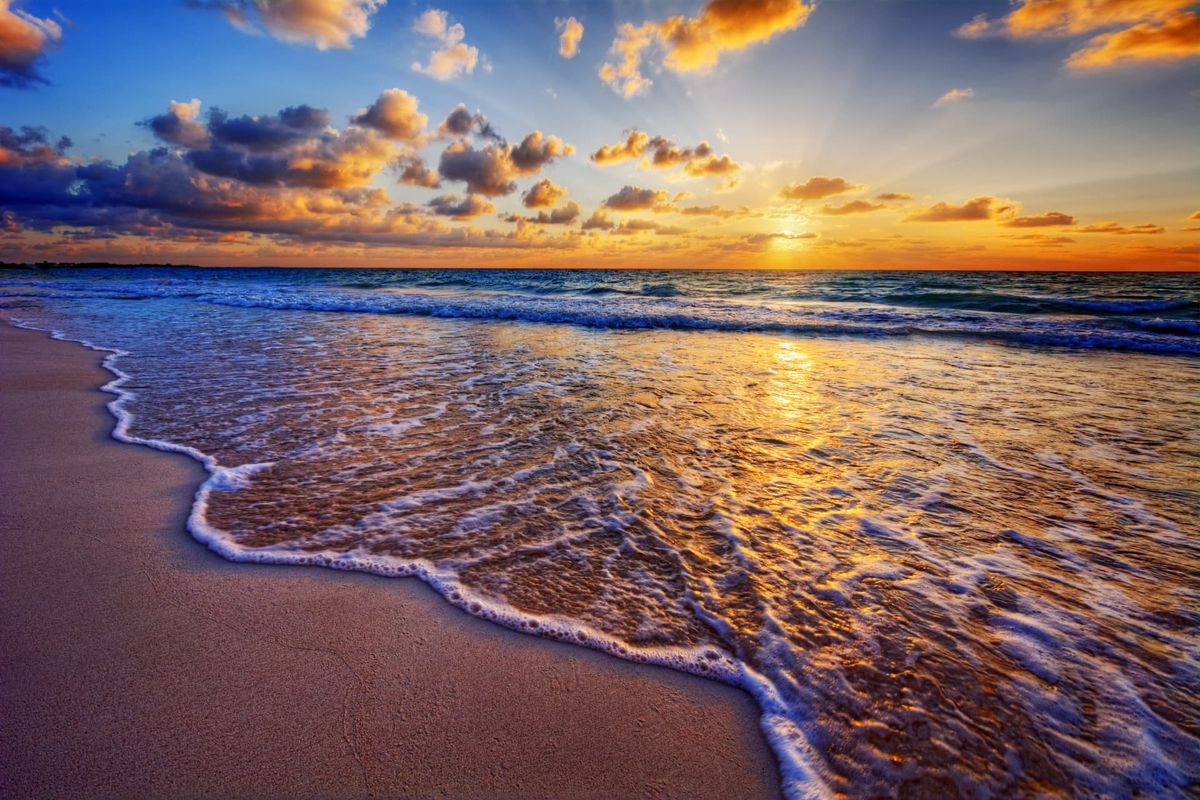 Gentle turquoise waves rolling onto a sunlit shore
